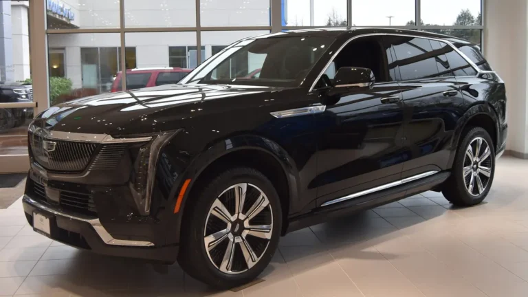 Black Cadillac Escalade IQ electric SUV, front three-quarter view; the 2027 Cadillac Escalade IQ adds NACS