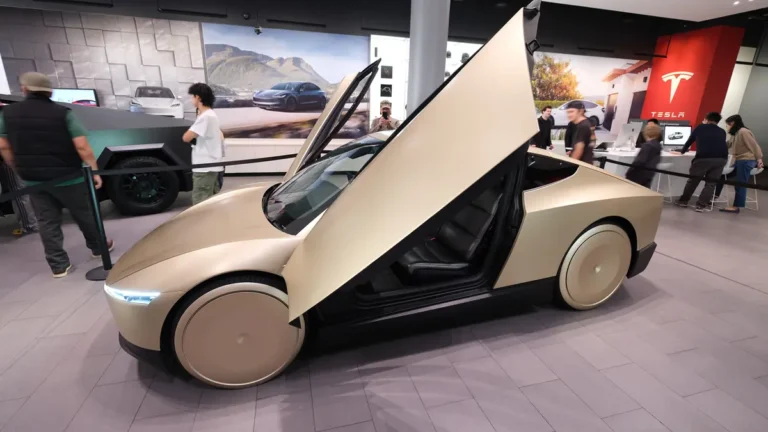 Gold Tesla Cybercab two-seat robotaxi with butterfly doors, oblique view