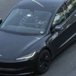 Black Tesla Model 3 Highland on a city street, the sedan at the center of the reported Tesla lease price increase
