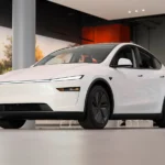 White 2025 Tesla Model Y on display inside a Tesla showroom at Santana Row, illustrating the Tesla Model Y APR increase to 2.49%