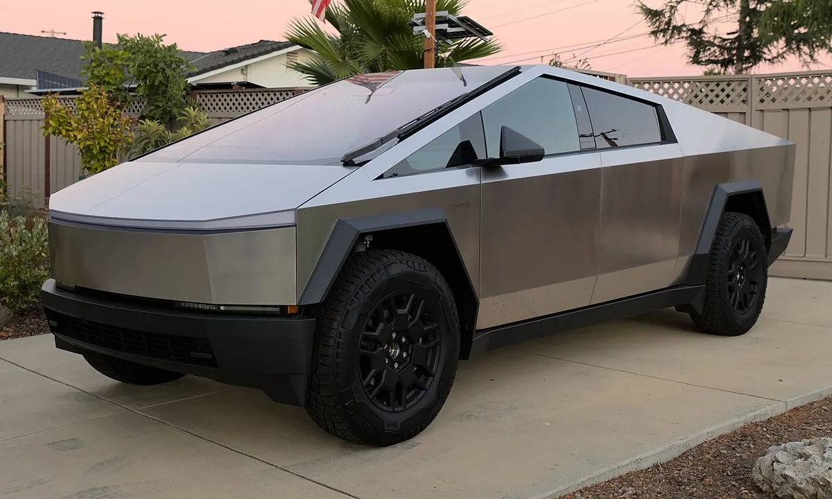 A stainless steel Tesla Cybertruck Foundation Series parked on a street in San Jose at dusk
