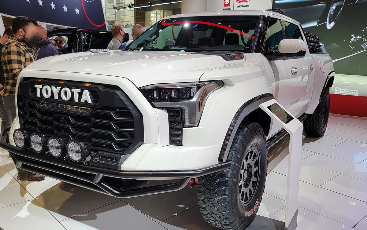 White 2022 Toyota Tundra TRD Pro on an auto show floor, front three-quarter view, a model eligible for Toyota Remote Connect