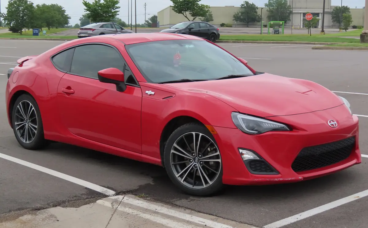 Red 2013 Scion FR-S sports coupe parked in a lot, front three-quarter view
